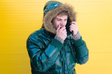 Üşütmüş ve grip olmuş. Soğuk kış koşulları için günlük moda ceketi. Takma kürk giyen yakışıklı bir adam. Soğuk hava tarzında modaya uygun bir adam. Moda modeli sıcaklığın ve konforun tadını çıkarıyor.