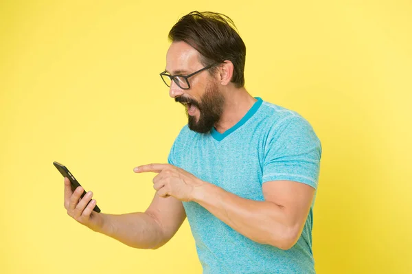 Toepassing downloaden. Hipster vrolijke gebruik smartphone. Man gelukkig gebruiker van de smartphone. Blijf in contact met de smartphone. Word lid online gemeenschap. Gebruiker vriendelijk concept. Man opgewonden smartphone kansen — Stockfoto