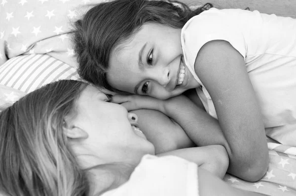 Mutlu çocuklar. İki küçük kızla mutlu çocuk günü. Yatakta gülümseyen küçük kızlar. aile kavramı — Stok fotoğraf