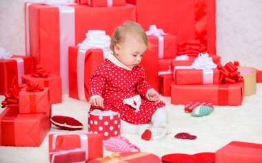 Bebek ilk Noel bir kez ömür boyu olay. Çocuk için ilk hediyeler Noel. Küçük bebek sarılmış kırmızı hediye kutuları yığını oynamak. İlk Noel'im. Önce Bebek sevinci paylaşımı aile ile Noel