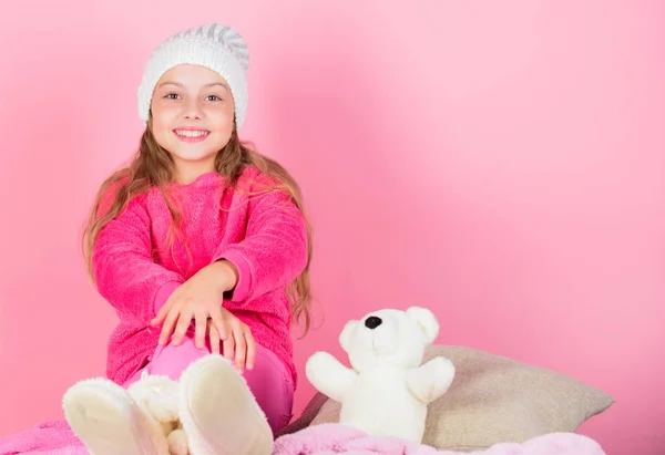 Kid cute girl play with soft toy teddy bear pink background. Teddy bears improve psychological wellbeing. Child small girl playful hold teddy bear plush toy. Unique attachments to stuffed animals
