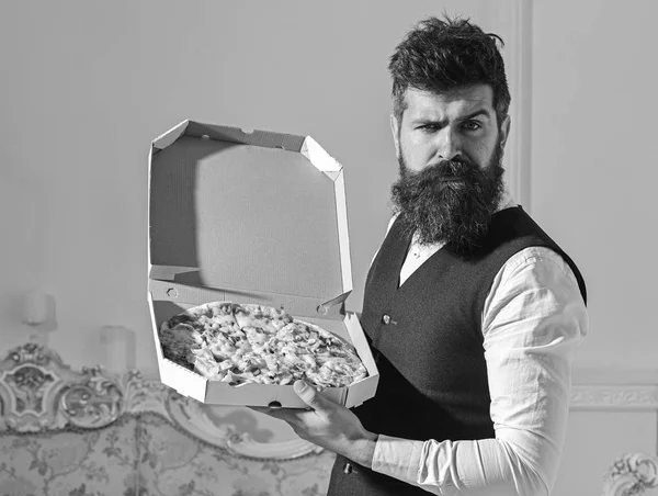 Koncepcja dostawy pizzy. Człowiek z broda i wąsy pole posiada dostarczane z smaczne, świeże, gorąca pizza. Macho w klasyczne ubrania głodny, na twarzy ścisłe, zamiar zjeść pizzę, luksusowe wnętrza tła — Zdjęcie stockowe