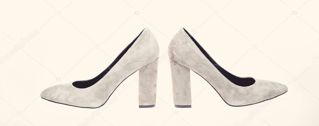 Shoes made out of grey suede on white background, isolated. Footwear for women with thick high heels, side view. Female footwear concept. Pair of fashionable high heeled shoes