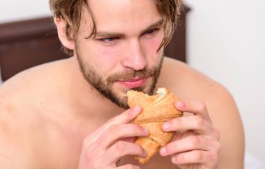 Adam yatakta gündoğumu ışıkta sabah espresso kahve içme sakallı. Yatak odasında eğleniyor büyük çıplak kaslı adam. Yatakta yemek.