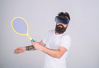 Vr gözlüklü play tenis raket ve top ile. Adım, gri arka plan yenerek Vr bardaklarda sakallı adam. Sanal spor kavram. Hipster meşgul yüzündeki kullanın modern teknoloji spor oyunları