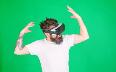 Hippi ilham ifade ile modern aracı Vr keşfetmek ile. VR gadget kavramı. Adam kafa monte ekran ile etkileşim içinde sanal gerçeklik. Vr gözlük, yeşil arka planda sakallı