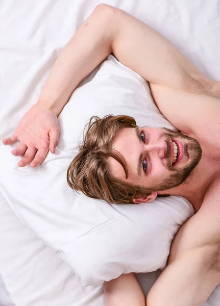 Duerme una cantidad adecuada y constante de sueño todas las noches. Cuánto sueño necesitas en realidad. Hombre barbudo durmiendo cara relajante en la almohada. Un hombre guapo yacía en la cama. Consejos de expertos para dormir mejor —  Fotos de Stock