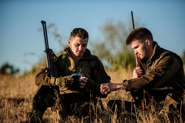 Los amigos cazadores disfrutan del ocio. Caza con amigos ocio hobby. Cazadores satisfechos con la bebida de calentamiento de captura. El descanso para los hombres de verdad concepto. Cazadores con rifles relajantes en ambiente natural —  Fotos de Stock