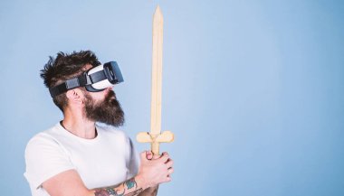 Hipster ciddi bir yüz üzerinde sanal gerçeklik oyun oyun keyfini çıkarın. Vr gözlük, açık mavi renkli sakallı adam. Oyun kavramı. Adam kafa monte ekran ile kılıç, oyun Vr oyunda mücadele tutar