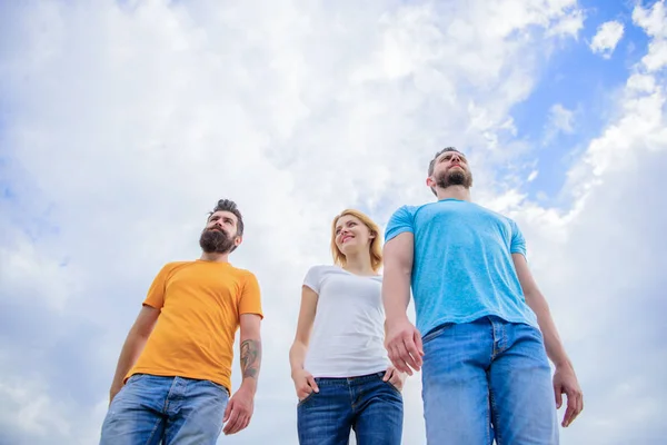 Trendy kleding dragen. Mooie vrouw en mannen vrienden buiten lopen. Groep mensen in vrijetijdskleding. Jongeren in casual stijl op bewolkte hemel. Mode mensen kijken casual in zomer outfit — Stockfoto