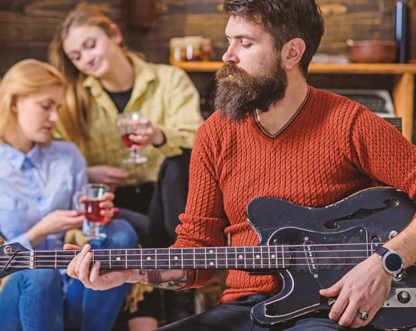 Guitarist playing at birthday, celebration concept. Bearded man performing guitar solo. Man with stylish beard entertaining guests at party. Musician spending lovely evening with wife and daughter
