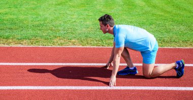 Zafer için çaba. Runner gitmeye hazır. Yetişkin runner yarış Stadyumu'nda hazırlayın. Nasıl yayınlanmaya başlaması. Spor motivasyon kavramı. Adam atlet runner standı düşük başlangıç pozisyonu stadyum yolu güneşli gün