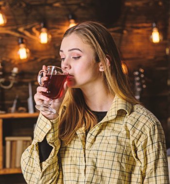 Bayan sıcak bir atmosferde, ahşap iç mulled şarap tadını çıkarın. Kız kareli giysiler dinlendirici, rahat yüzündeki kapatın. Dinlenmek ve rahatlamak kavramı. Rahatlatıcı ve mulled şarap içme kız