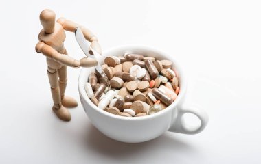 Vitamin kokteyli. Sağlık problemi. Bağışıklık ve ilaç vitaminleri. İlaçları karıştırıyorum. Hızlı tedavi. İlaç reçetesi. Bardağın yanında tahta insan kuklası dolu haplar ve tabletler. İlaç konseptini al
