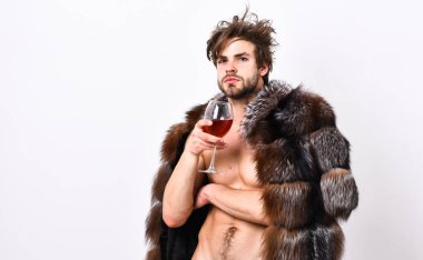 Sexy sleepy rich macho tousled hair drink wine isolated on white. Fashion and pathos. Richness and luxury concept. Guy attractive rich posing fur coat on naked body. Rich athlete enjoy his life clipart