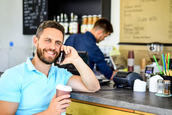 あなたを待っています。男のスマート フォン注文のカフェでコーヒー。コーヒー ブレークのコンセプトです。コーヒーは、忙しい人のためのオプションを奪います。男モバイルで会話カフェ バリスタ背景。待っている間にコーヒーを飲む — ストック写真