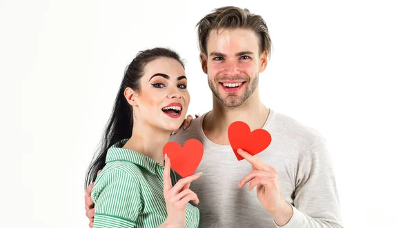 Handsome unshaven man and pretty girl in love. Valentines day and love. Romantic feelings concept. Man and woman couple in love hold red heart card on white background. Romantic couple in love hug — Stock Photo, Image