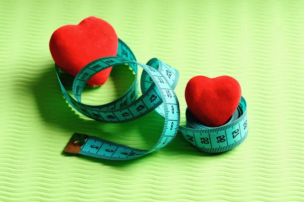 Workout and sport concept. Heart decorations and flexible ruler
