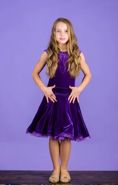 Одяг для бальних танців. Дитяча модна сукня виглядає чарівно. Концепція моди в бальному одязі. Дитяча танцівниця задоволена концертним вбранням. Дитяча мода. Дівчина мила дитина носить оксамитову фіолетову сукню — стокове фото