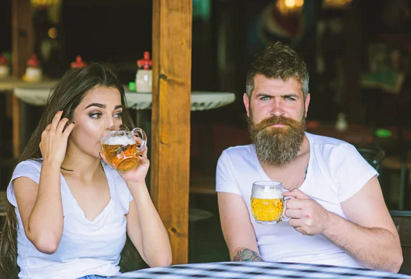 Pareja enamorada en la cita bebe cerveza. Hombre barbudo hipster y chica con vaso de cerveza lleno de cerveza artesanal. Una reunión amistosa solo bebe cerveza. Un par de citas brutales en el pub. Mejores amigos o amantes de beber en el pub —  Fotos de Stock