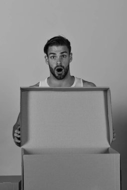 Elinde boş karton kutu tutan kıllı bir adam.