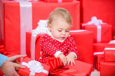 Çocuk için ilk hediyeler Noel. İlk Noel kutlaması. Önce Bebek sevinci paylaşımı aile ile Noel. Bebek ilk Noel bir kez ömür boyu olay. Küçük bebek kız oyun hediye kutuları yığını