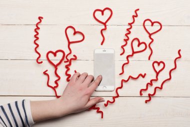 Telefon ekran bulanık tel kalpler tarafından çevrili dokunmadan el