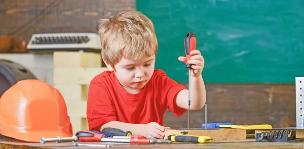 Gyerek tanulás csavarhúzóval. Koncentrált gyerek javítások a műhelyben dolgozik. Jövőbeli foglalkozás koncepció — Stock Fotó