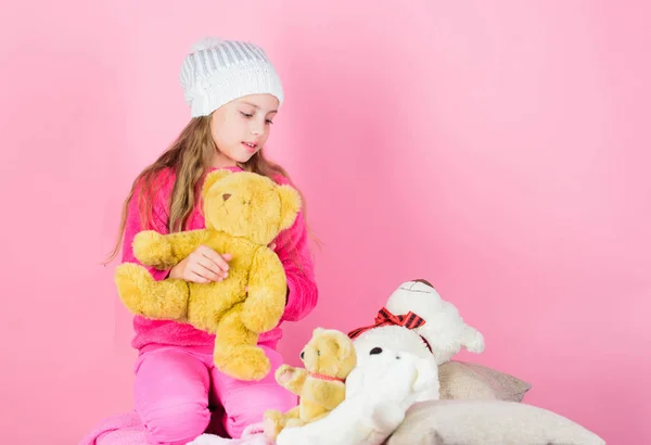 Child small girl playful hold teddy bear plush toy. Teddy bears improve psychological wellbeing. Kid little girl play with soft toy teddy bear pink background. Unique attachments to stuffed animals