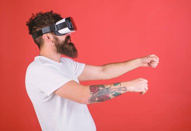 Hippi emin yüz sürüş bisiklet sanal gerçeklik ile modern dijital becerikli alet. Vr sakallı sürüş motosiklet, kırmızı arka plan gözlük. Sanal sürüş dersleri kavramı