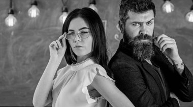 Sakal ve gözlük stand sırt sırta, kara tahta arka plan öğretmen olan adam. Bayan ve birlikte okulda çalışan hippi. Ekip çalışması kavramı. Öğretmen ve öğretmen rahat görünüyor
