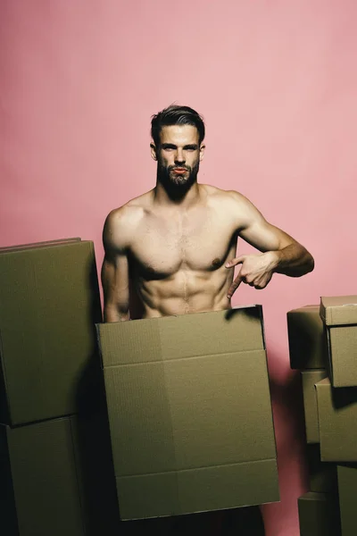 Loader with serious face covers nudity, points to box