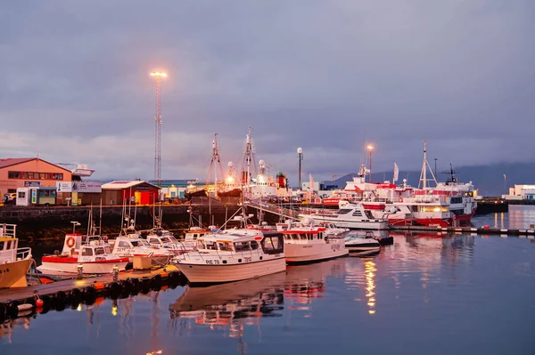 Reykjavik, Islandia - 14 de octubre de 2017: yates en las luces del muelle al atardecer. Barcos de vela en la costa en el cielo de la noche. Transporte de agua y viajes por mar. Vacaciones o ansia de viajar y viajar — Foto de Stock