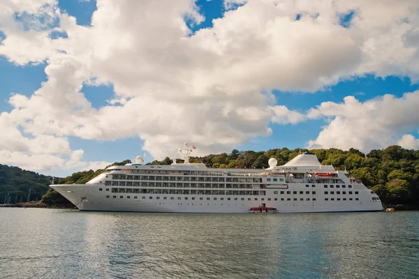 Krydstogtskib ved havet i Fowey, Det Forenede Kongerige. Ocean liner i havet på overskyet himmel. Sommerferie på tropisk ø. Rejser med vand med opdagelse. Wanderlust og eventyr - Stock-foto