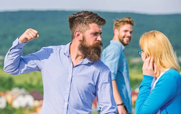 Husband strictly watching his wife looking at another guy while walk. Violence concept. Man with beard jealous aggressive because girlfriend interested in handsome passerby. Passerby smiling to lady — Stock Photo, Image