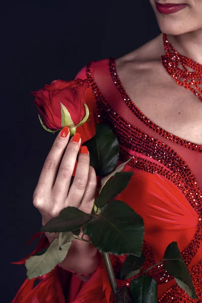 Rose blomma i kvinnlig hand i klänning på mörk bakgrund — Stockfoto