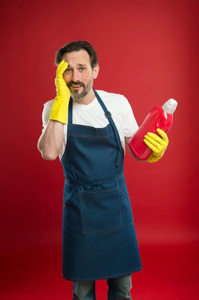 Man in apron with gloves hold plastic bottle liquid soap chemical cleaning agent. Cleaning day today. Bearded guy cleaning home. Cleanliness and order. Cleaning service and household duty. So dirty — Stock Photo, Image