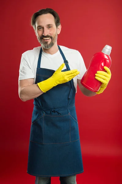 Cleaning day today. Bearded guy cleaning home. Cleanliness and order. Cleaning service and household duty. So dirty. Man in apron with gloves hold plastic bottle liquid soap chemical cleaning agent — Stock Photo, Image