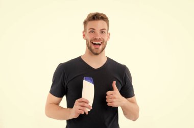 Mutlu bir adam şampuan şişesi kadar başparmak göster. Sakallı adam smile beyaz arka plan üzerinde izole jel tüp ile. Gibi ve onay işareti el. Sağlık ve sağlık. Spa ve banyo veya duş için kozmetik