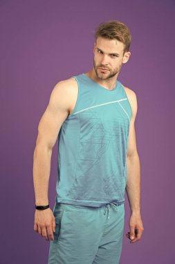 Sportif giyim, menekşe arka plan poz katı yüz kişi. Kıl adamla sportif giysiler ve fitness izci kümesi giyer. Moda kavramı. Erkek gömlek ve pantolon mavi kümesinde sportif görünüyor