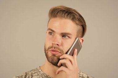 Sakallı adam konuşmak üstünde hareket eden telefon. Maço kullanma smartphone. Adam ile hareket eden aygıt. Dijital pazarlama, online olarak satın ve cyber Pazartesi kavramı. İletişim ve modern yaşam için yeni teknoloji.