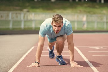 Adam runner üzerinde başlama pozisyonu Stadyumu'nda. Runner yüzey üzerinde başlangıç poz. Koşu parkuru açık koşan adam. Spor ve atletizm kavramı. Sporcu konsantre yüz hazır
