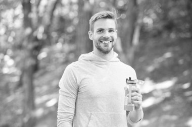 Atlet yüz tutun şişe bakım nemlendirici vücut egzersiz yaptıktan sonra memnun. Büyük iş sonra ferahlatıcı vitamin içeceği. Adam atletik görünüm su şişesi tutar. Sporcu içmek su maraton sonra