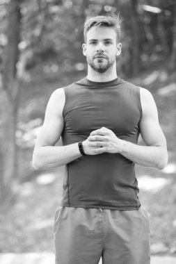 Adam sportif kıyafeti kendine güvenen açık havada doğa arka plan görünüyor. Adam kas vücut onun sportif şeklinde gurur sakallı. Sporcu kas vücut sabah çalıştırmak için hazır. Sağlığı ve sağlıklı vücut zevk