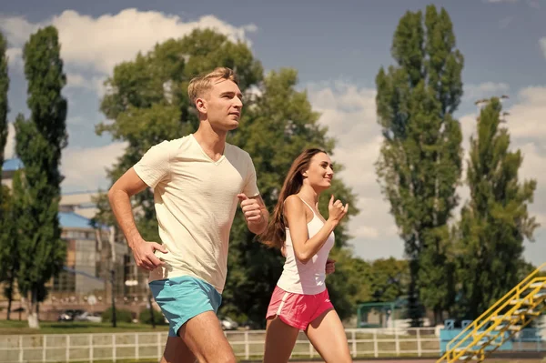 Couple running on arena track. — Stock Photo, Image