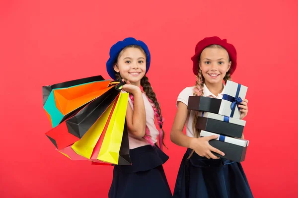 El mejor precio. Visita el centro comercial. Las niñas tienen bolsas de compras o paquetes de regalos de cumpleaños. Los sueños se hacen realidad. Feliz infancia. Concepto de compras. Niño lindo niñas pequeñas en gira de compras. Comprar ahora —  Fotos de Stock