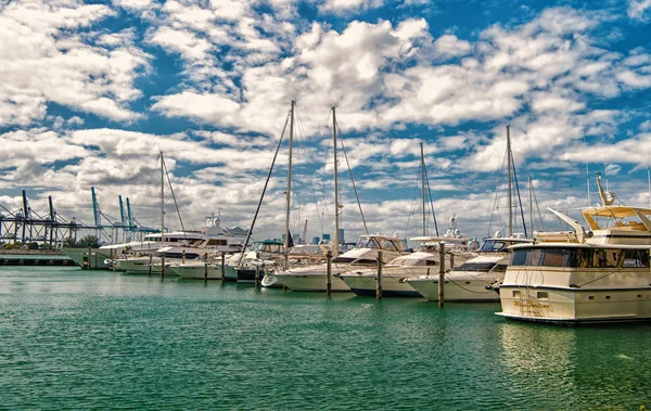 Майами, США - 19 февраля 2016 года: яхты и катера в морском порту на облачном голубом небе. Яхты и парусный спорт. Роскошное путешествие на лодке. Летние каникулы в море. Водный транспорт и корабль — стоковое фото