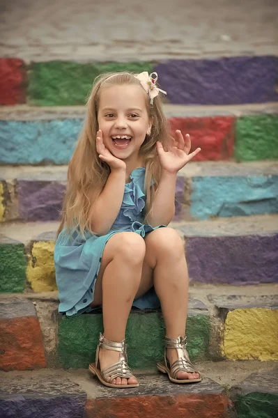 Małe dziecko szczęśliwy dziewczyna w niebieskiej sukience na schody kolorowe — Zdjęcie stockowe