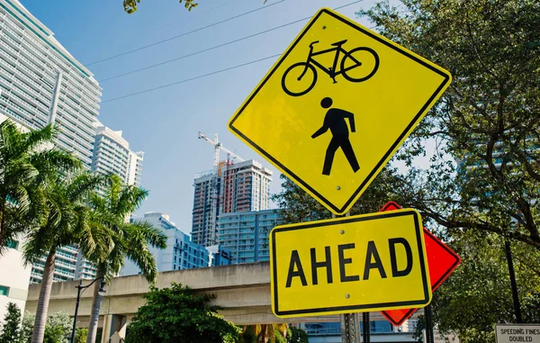 Traffic signs on city road in miami, usa. Bicycle and pedestrian crossing ahead warning. Transportation traffic and travel. Caution and warn concept