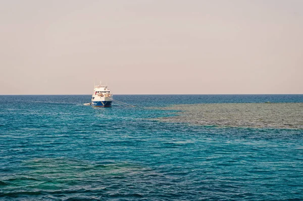 Πλοίο αγκυροβόλησε στο γαλάζιο ηλιόλουστο ουρανό ορίζοντα. Ταξίδι με πλοίο στη θάλασσα. Καλοκαιρινές διακοπές και αναψυχή. Θαλάσσια συγκοινωνία και σκάφος — Φωτογραφία Αρχείου